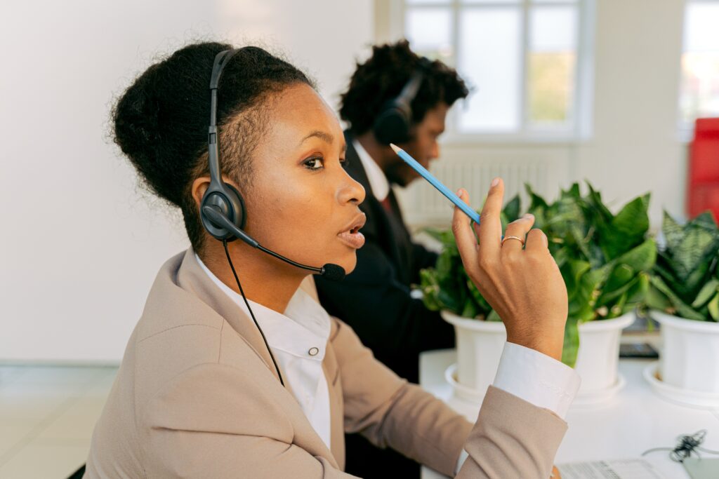 Two people working in an office with headsets on