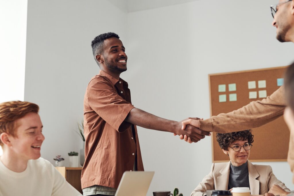 Two people shaking hands across a table