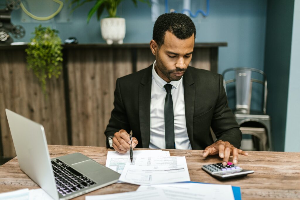 A man in a suit doing some calculating: outsourcing services