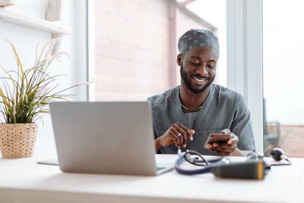 A man in scrubs using his cellphone: outsourcing services