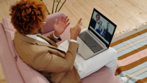 A man seated in front of his laptop having a virtual meeting: remote team