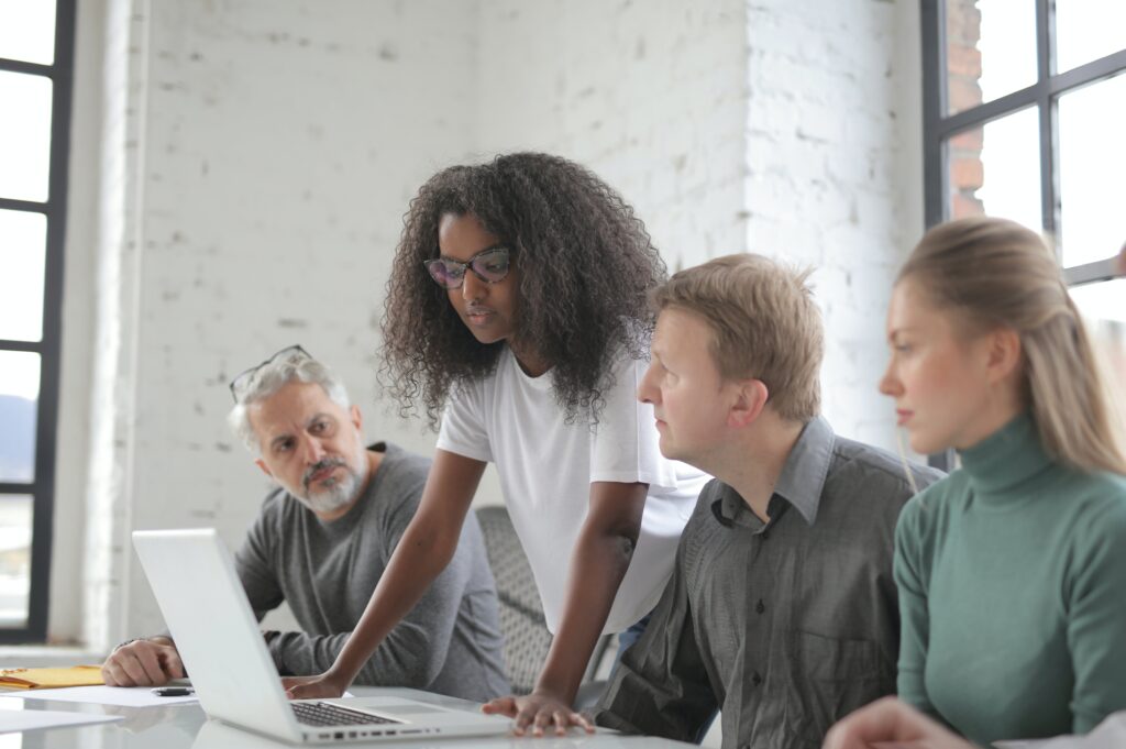 A team having a meeting while looking at a laptop: outsourced project manager