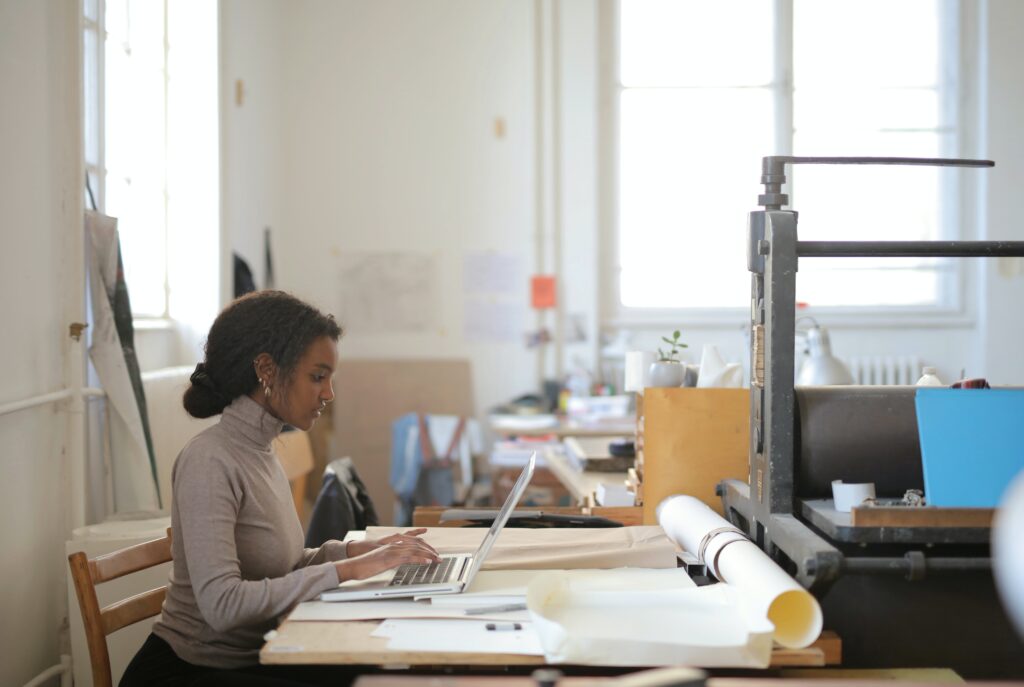 A woman sitting at a desk using a laptop: outsourced data entry