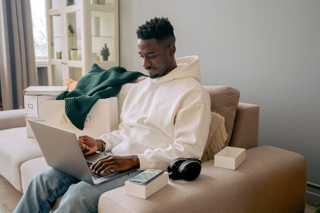 A man sitting on a sofa working on a laptop: outsourced data entry