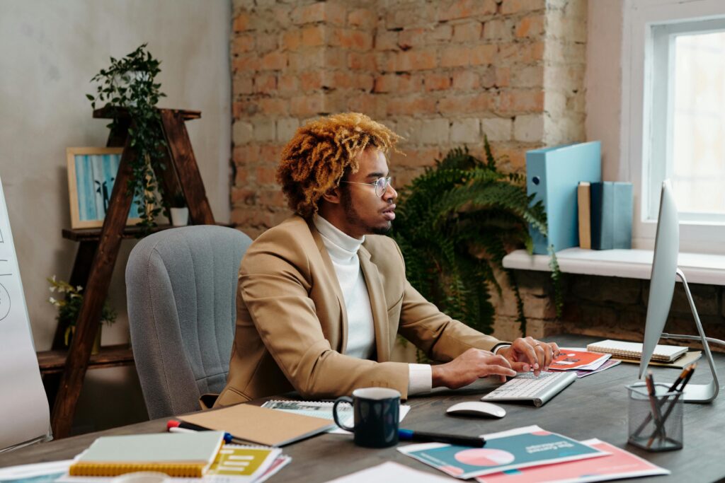 A man in a brown blazer busy working: outsourced receptionist