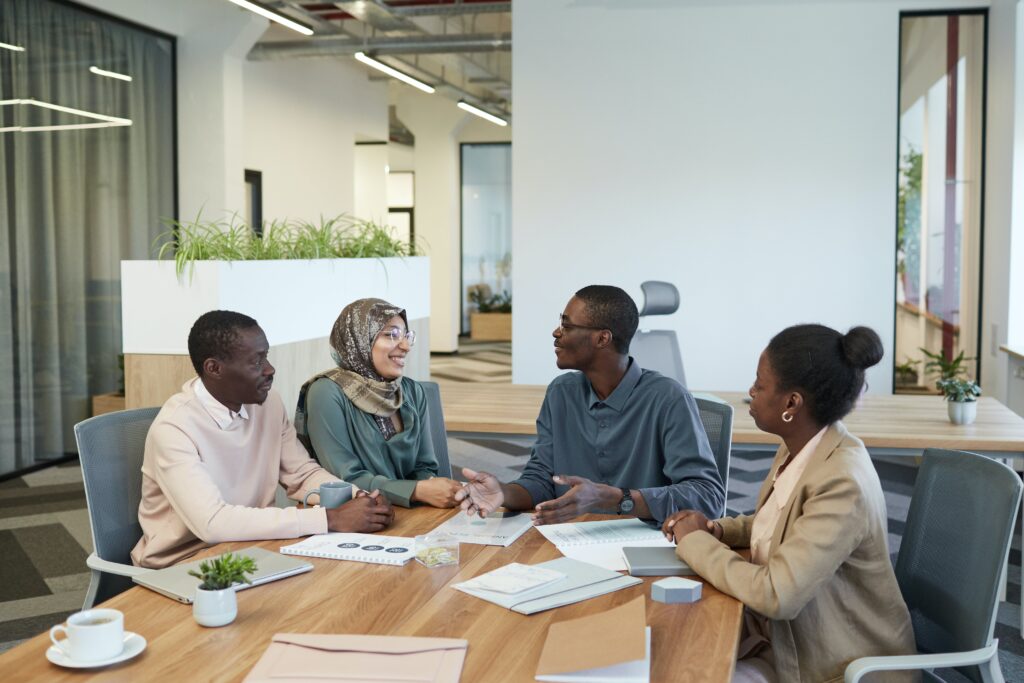 People seated at a table having a meeting: outsourcing risk management