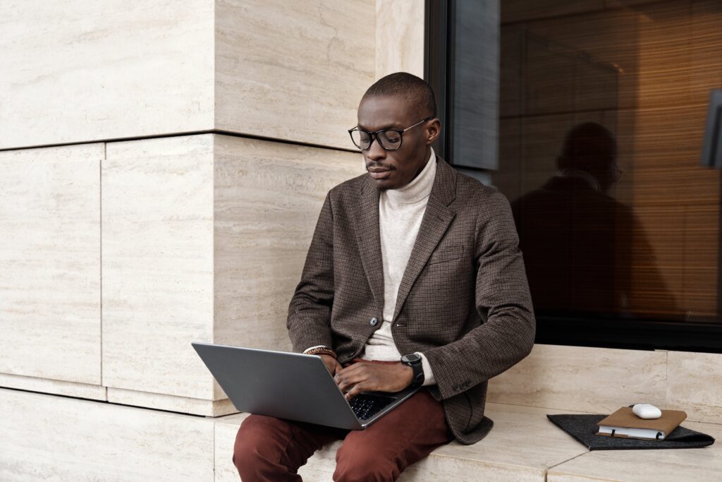 A businessman working on a laptop outside: outsourced data entry